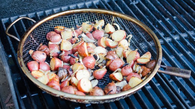 Red potatoes and Onions cooking on a grill