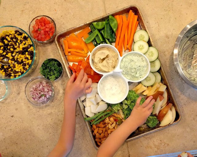 Sheet pan full of vegetables, nuts, meat and dips
