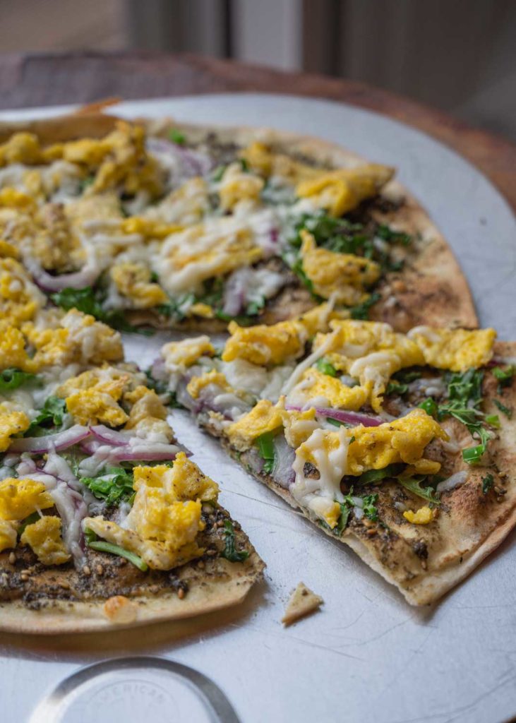 Flatbread pizza with eggs on a pizza peel